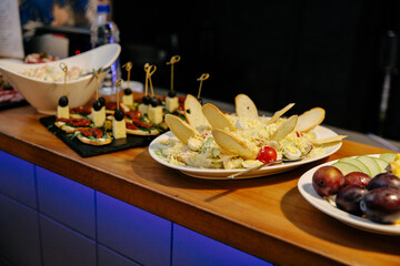 Meal. Festive buffet table for guests. Assortment of cold cuts,canapes on wooden skewers, festive snacks with fruits and salads. Reception at the party.
