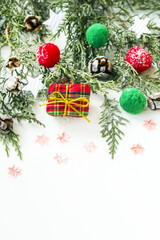 Christmas border with snowy pine leaves and christmas decorations on white surface with copy space