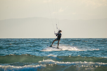 Woman kitesurfer athlete ready for trick on sea
