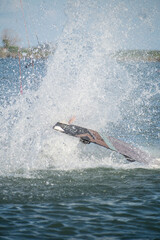 Kitesurfer athlete splashes on sea after a trick