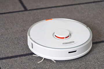 robot vacuum cleaner performs automatic cleaning on carpet. close up