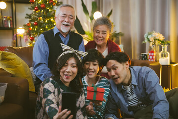 Asian family taking selfie near Christmas tree together at home. Family, holidays, Christmas concept
