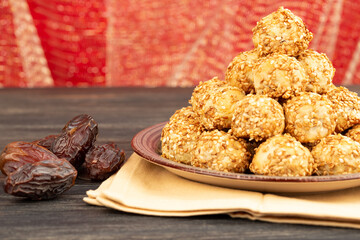 Greek and Cyprus traditional Christmas date cookies with sesame seeds on wooden background.