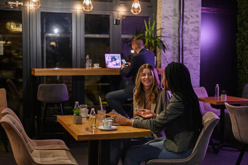 Two businesswoman having a meeting in a cafe while using a laptop