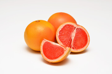 whole and cut grapefruits close-up on a white background