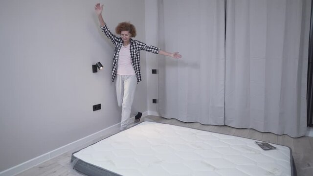 Senior woman feeling happy about her new comfortable mattress at home. Concept of healthy sleep. Comfortable sleep. An elderly woman is happy with a new mattress in a new rented apartment.