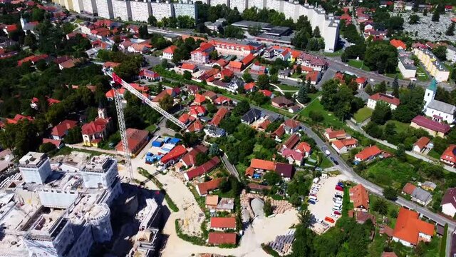 View of the reconstruction of Di&oacute;sgy&otilde;r Castle. Construction cranes and residential buildings. Green trees on the hills in Miskolc. Drone Video. Hungary. Europe