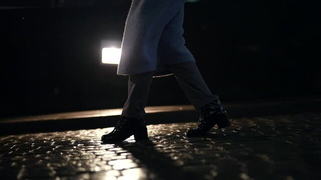 night walk in city, closeup view of female legs, strolling over cobblestone road