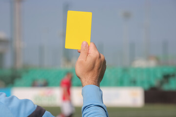 Football referee shows a yellow card. 