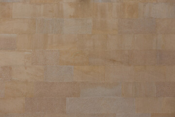 Fototapeta premium The wall is of sawn yellow sandstone.