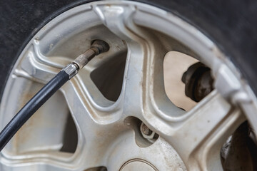 Checking tire pressure. Pumping air into auto wheel.