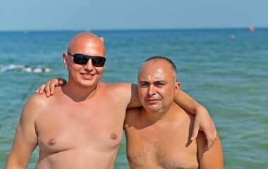 Friends with families with children are resting on the seashore.