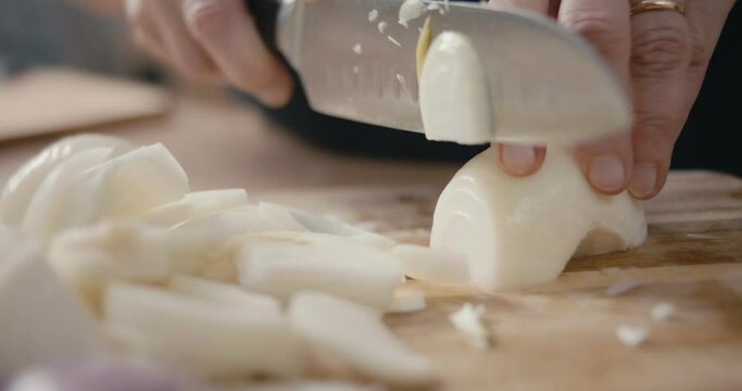 Senior cook chop or chopping onion kitchen board hand knife close up