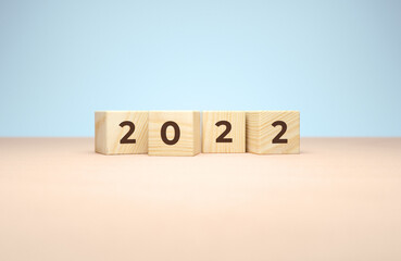 New year 2022 wooden cubes in 3d rendering on a minimal background. Holiday illustration for poster or greeting card design concept in realistic 3D rendering