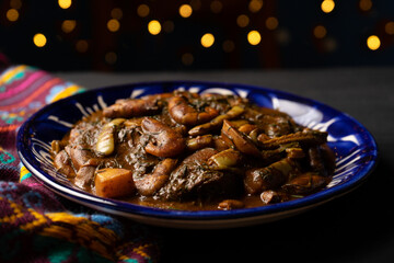 Mexican romeritos with mole sauce and shrimp on a dark background
