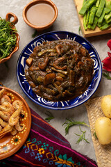 Mexican romeritos with mole sauce and shrimp on a gray background