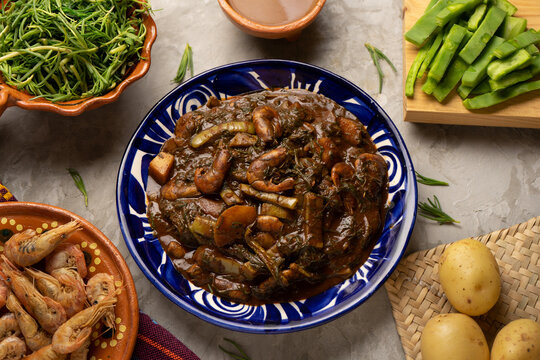 Mexican Romeritos With Mole Sauce And Shrimp On A Gray Background