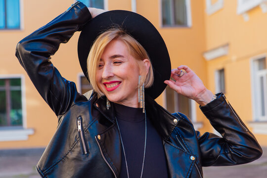 Closeup portrait of a pretty girl wearing hat and leather jacket outdoors.