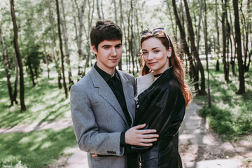 beautiful couple in love hugging each other and standing next to each other. valentines day. guy and girl are connected with each other in love. Happy couple smiling having fun while relaxing outdoors