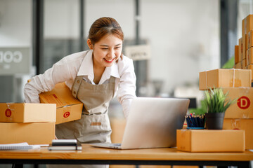 Portrait of Starting small young businesses SME owners female entrepreneurs working on receipt box and check online orders to prepare to pack the boxes, sell to customers, SME business ideas online.