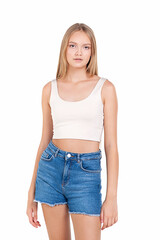 Teenager girl with long blond hair in denim shorts on a white background