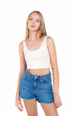 Teenager girl with long blond hair in denim shorts on a white background