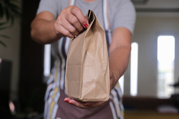 person handing over paper bag