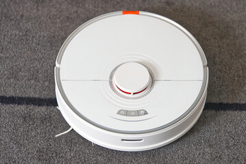 robot vacuum cleaner performs automatic cleaning on carpet. close up