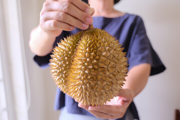 close up of a person holding a big Durian fruit