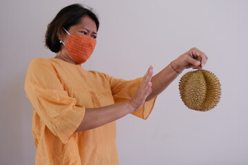 Woman refusing to eat smelly Durian fruit - obrazy, fototapety, plakaty