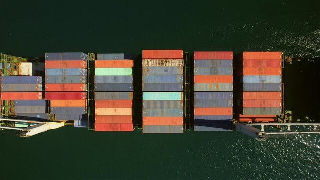 Aerial view of small feeder container cargo vessel at anchor 