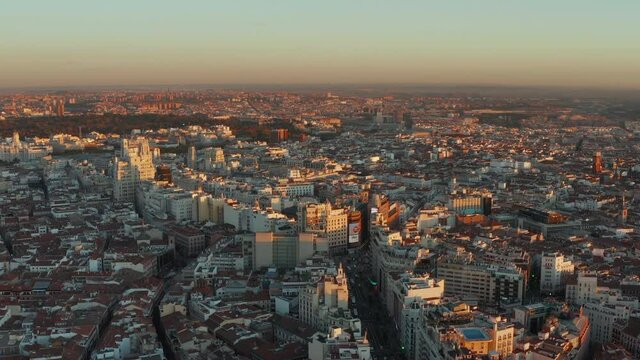 Ascending footage of town at sunset. Aerial panoramic shot of city centre with famous shopping Gran Via street.