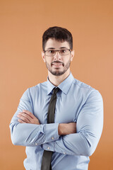 Portrait of confident smiling young entrepreneur folding arms and looking at camera