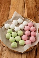 Raw Three Color Raw Tangyuan in a Sieve over Wooden Table, Concept of Preparing Food Dessert for Winter Solstice (Dongzhi) Festival Family Gathering.