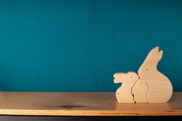 There are three wooden hares on the shelf, symbolizing the family. Place for an inscription, empty...