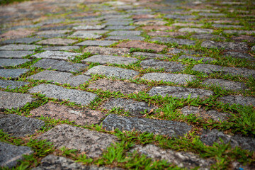 Cobblestone street texture. Regular shapes of cobblestone road, abstract background of old cobblestone pavement close-up.