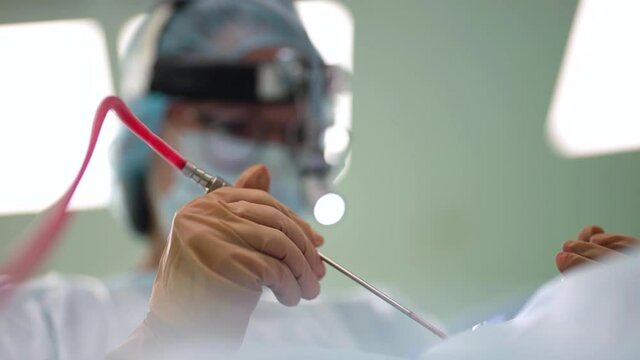 oncologist is removing tumor by modern endoscopic method, surgeon in operating room