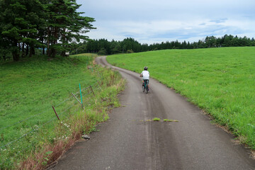 Obraz premium 日本の田舎道をサイクリングする子供