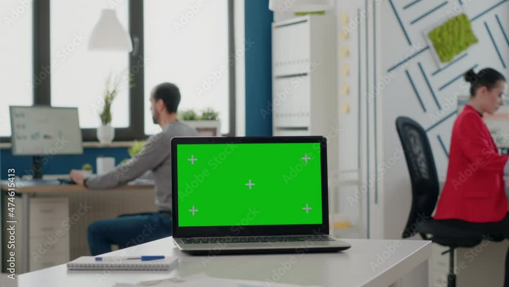 Poster close up of laptop with green screen on empty desk in business office. mock up template with isolate
