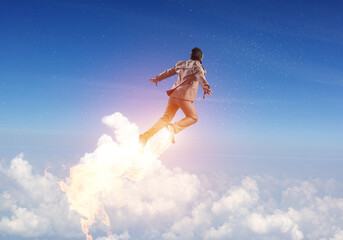 Businessman in suit and aviator hat flying in sky