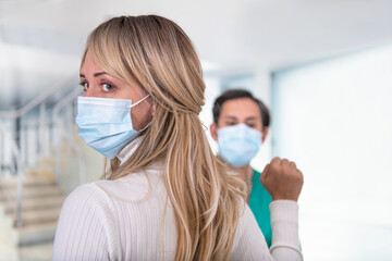 Woman looking back and doing new hand sign advertising that one is a victim of domestic violence. 