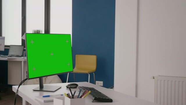 Company worker using green screen on computer at desk. Woman working with isolated mock up template and chroma key on background. Monitor with mock-up copy space on display in office.