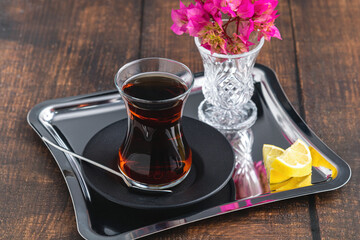 Top view of traditional black turkish tea with lemon and cookies on wooden background