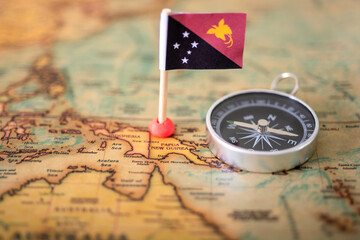 Fototapeta na wymiar the flag of Papua New Guinea, and the compass on the world map.
