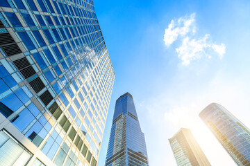 Obraz premium Modern office building with glass facade on a clear sky background. Transparent glass wall of office building.