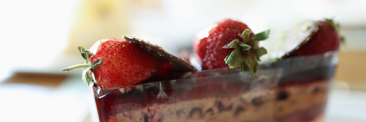 Chocolate puff cake with strawberries on white plate closeup