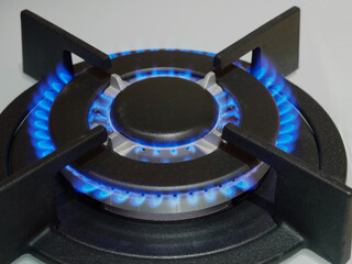 Close up of Gas kitchen stove cook with blue flames burning. Panel from steel with a gas.