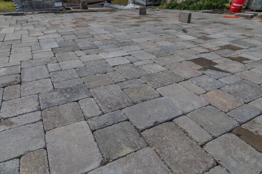 Closeup shot of a newly built concrete paver patio hardscape surface being installed in a landscape