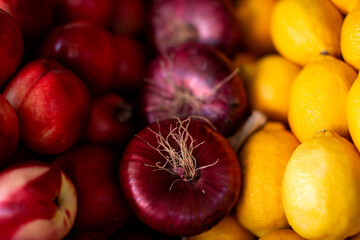 Onions, lemon, nectarine lying on the counter. Close-up.