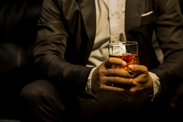 Closeup businessmen holding a glass of whiskey